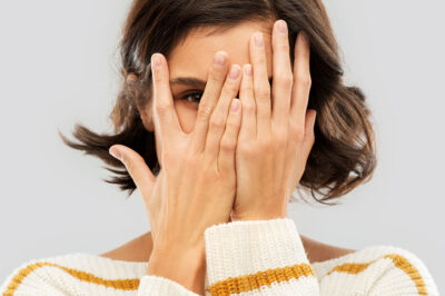 Młoda kobieta zasłaniająca twarz